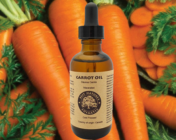 Bottle of carrot oil with a dropper surrounded by fresh carrots