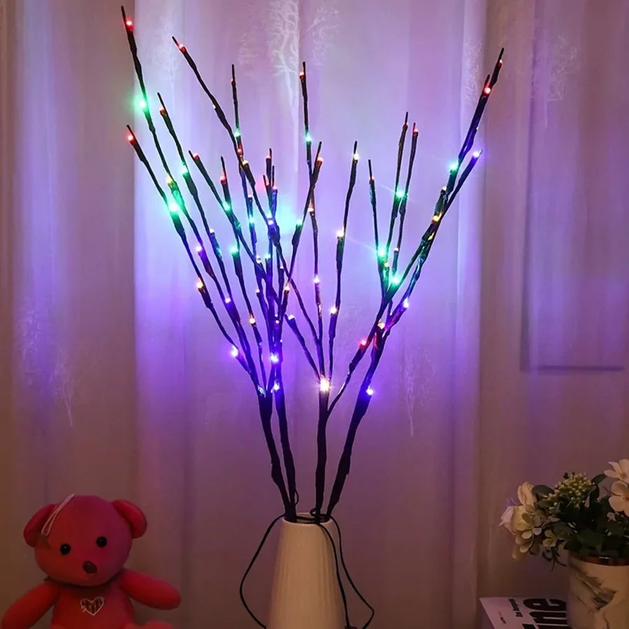 Decorative LED branch with multicolor lights in a vase against a curtain background
