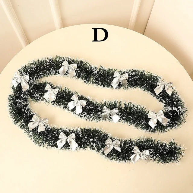 Decorative tinsel with silver bows on a beige surface
