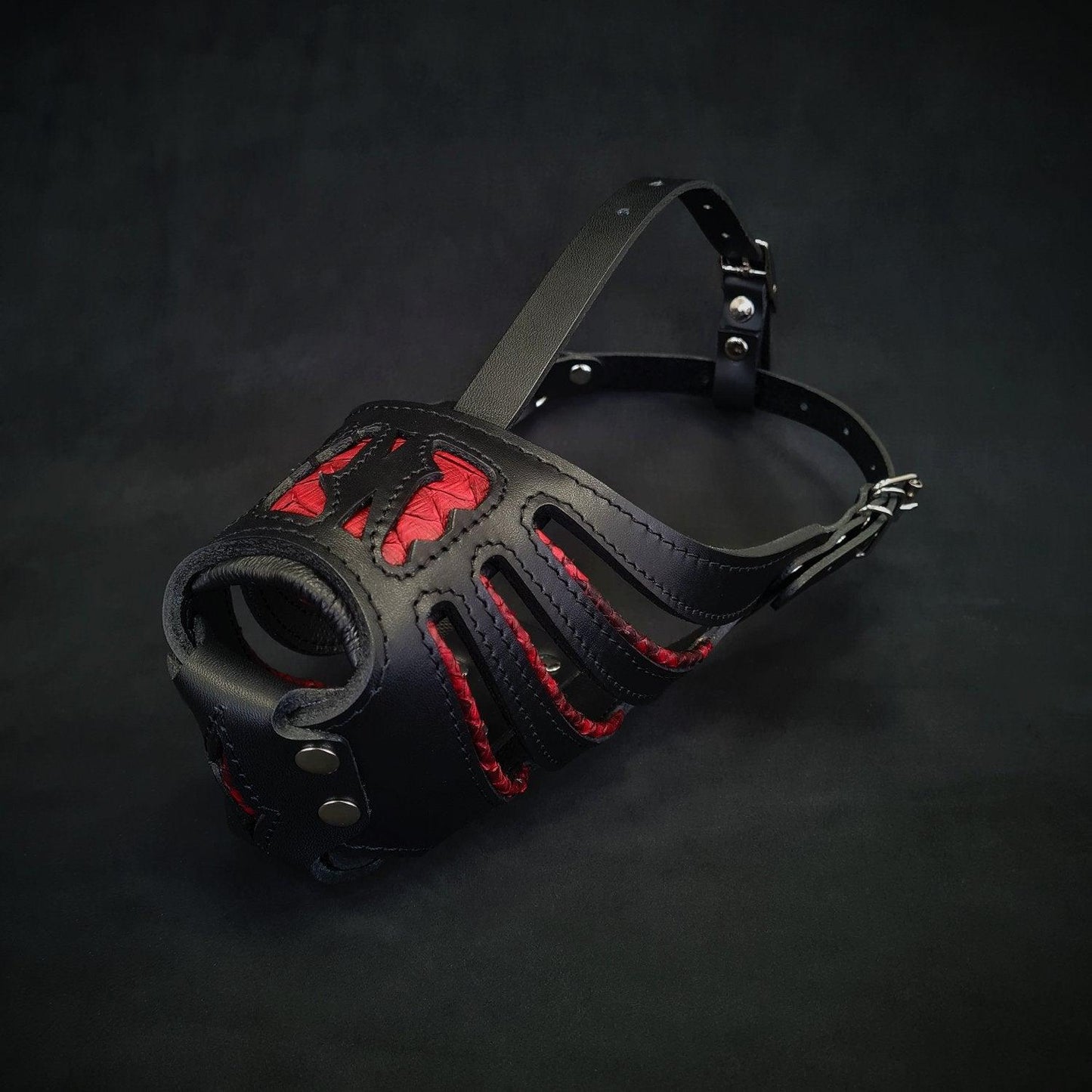 Black leather muzzle with red interior on a dark background