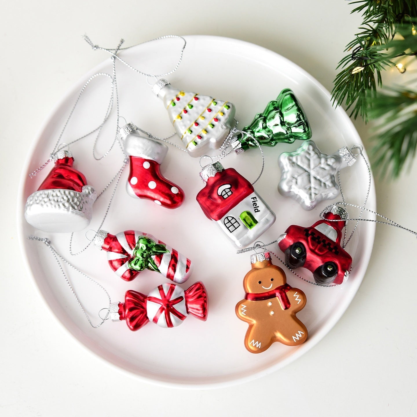 Collection of colorful Christmas ornaments on a white plate with a festive background.