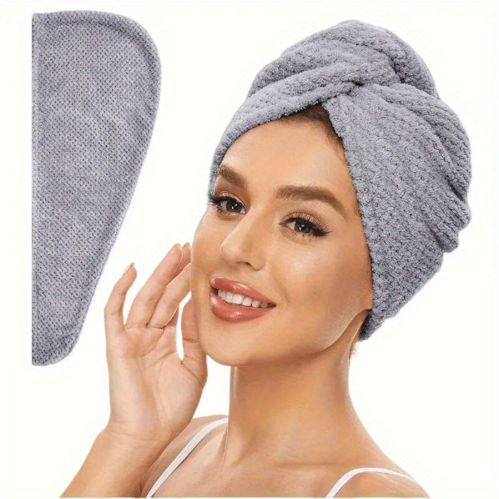 Woman wearing a gray hair towel with a matching hair dryer on a white background
