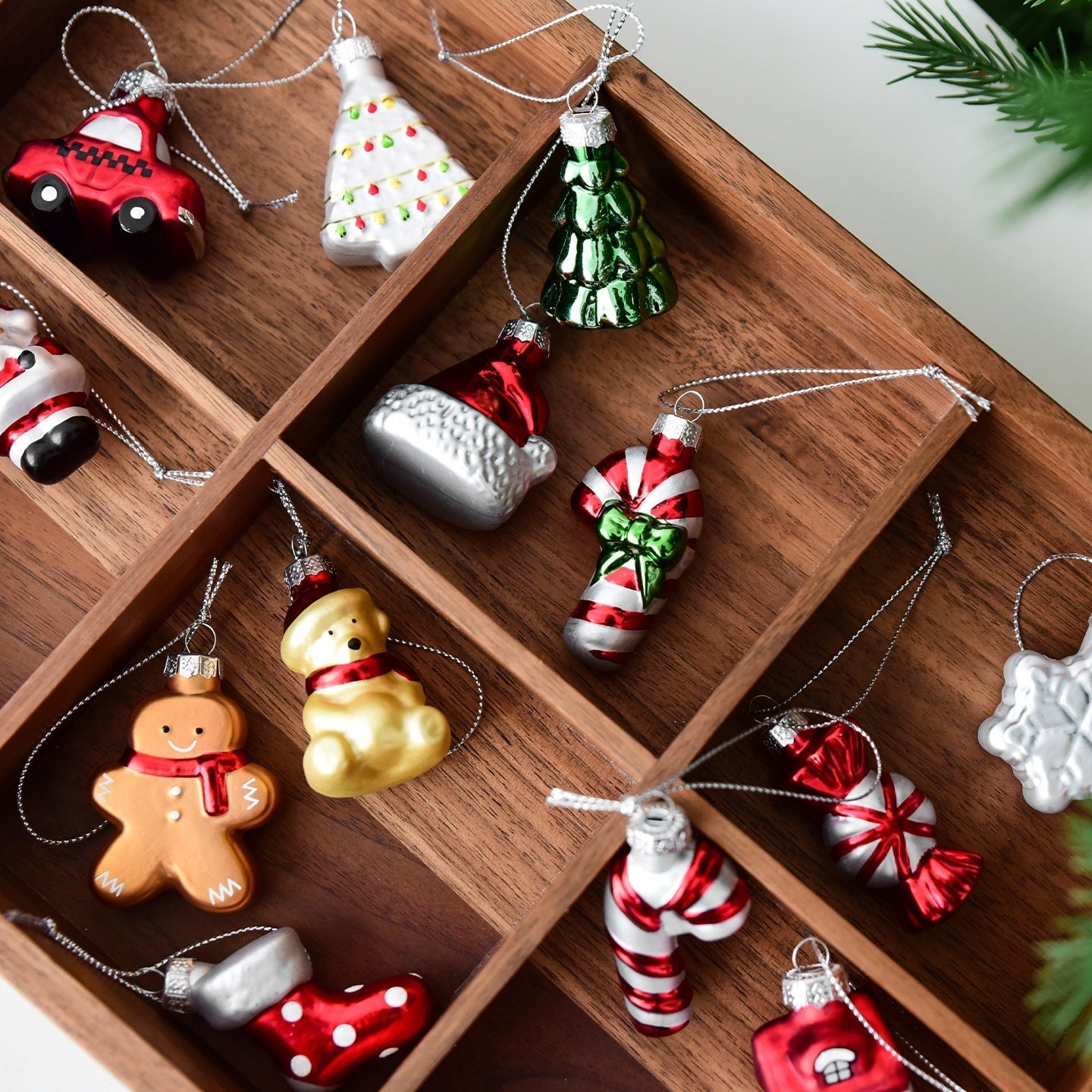 Collection of colorful Christmas ornaments on a wooden shelf.