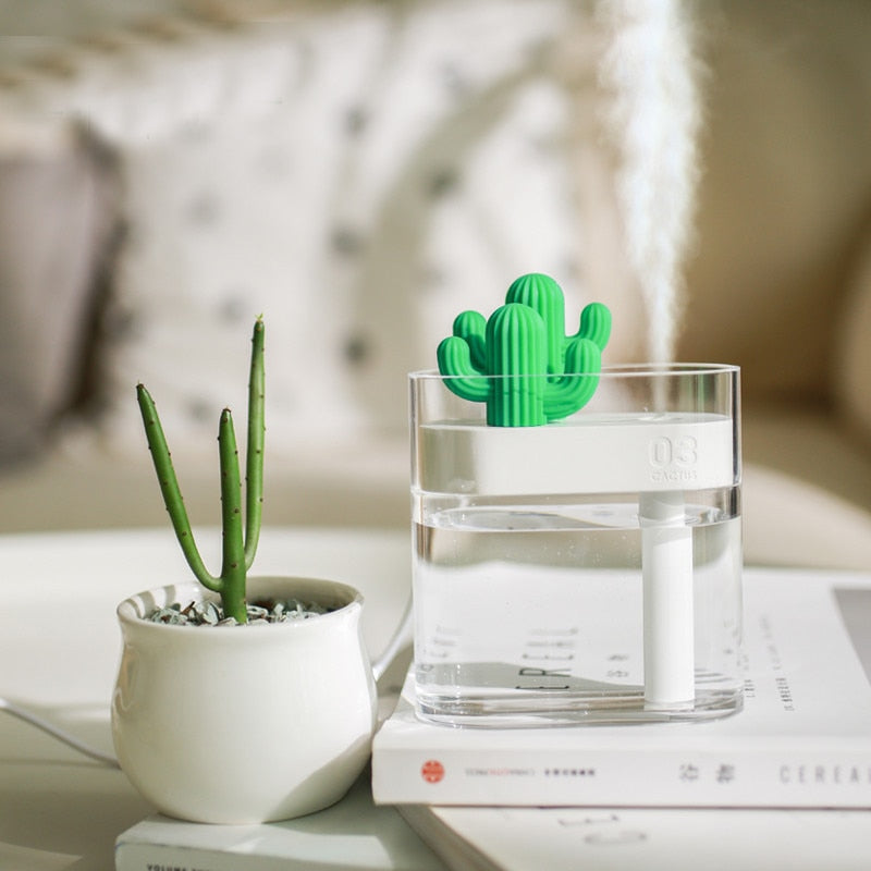 Cactus-shaped desk organizer with a glass of water on a table