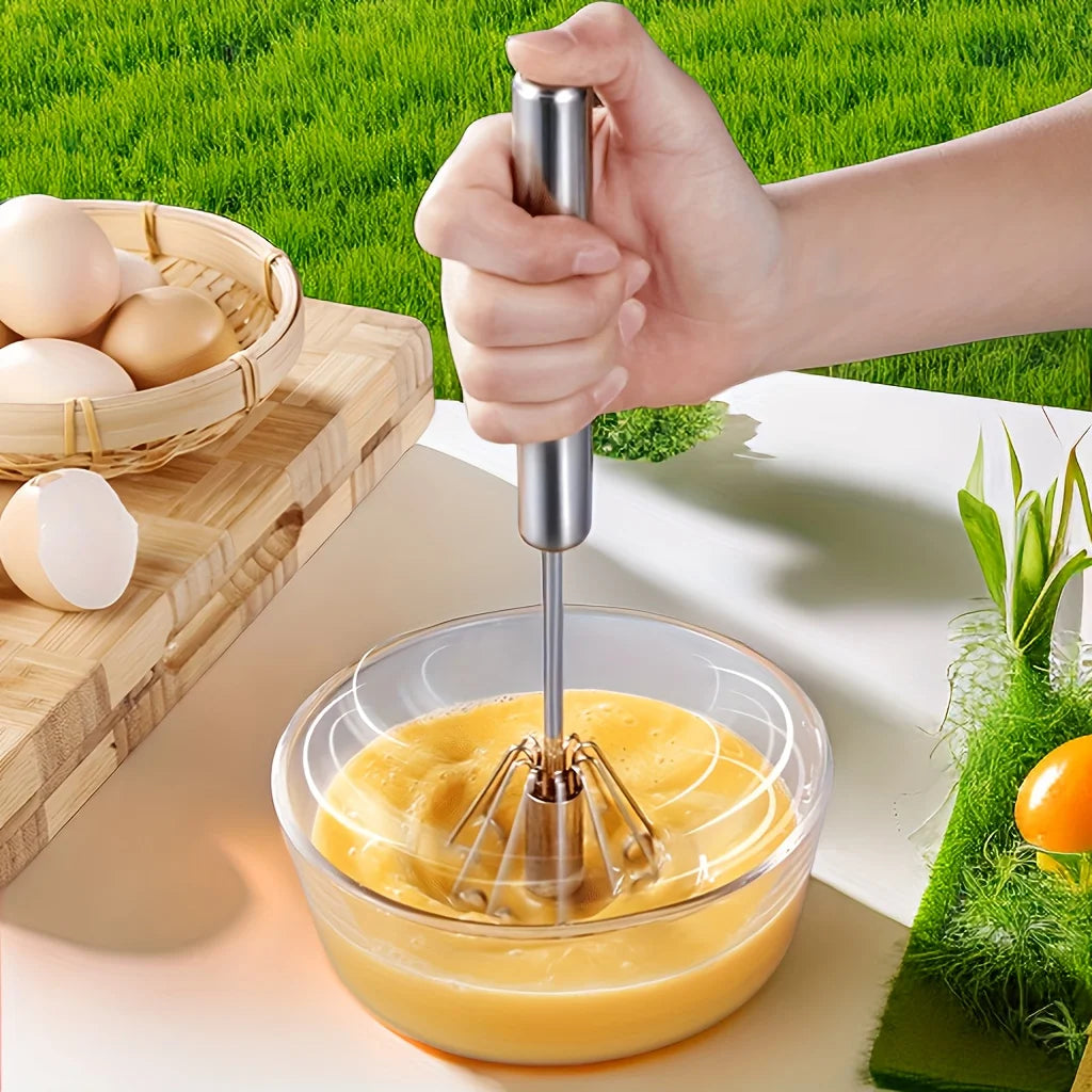 Hand using a hand mixer to blend eggs in a bowl with a green outdoor background