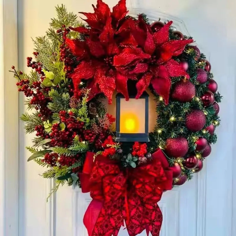 Decorative Christmas wreath with red poinsettias, berries, and a candle on a white door.