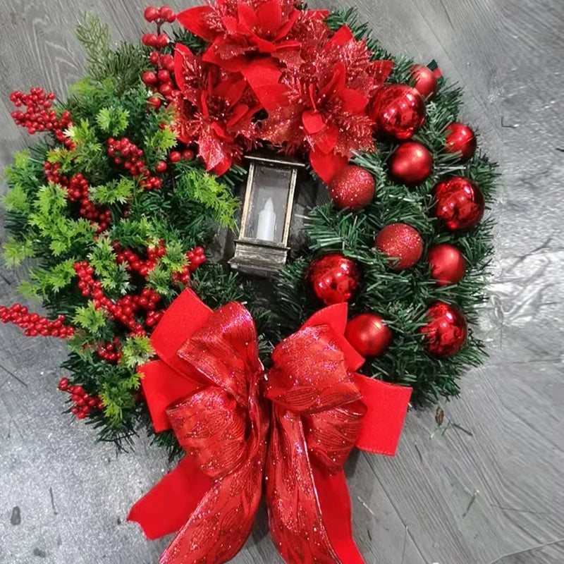 Decorative Christmas wreath with red ornaments and ribbons on a wooden surface