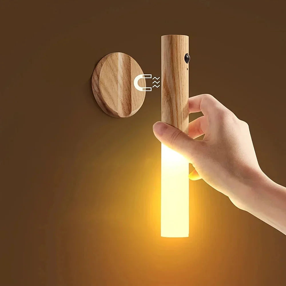 Wooden wall light fixture with a hand turning it on against a brown background
