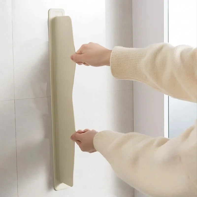 Person using a beige handrail on a tiled wall