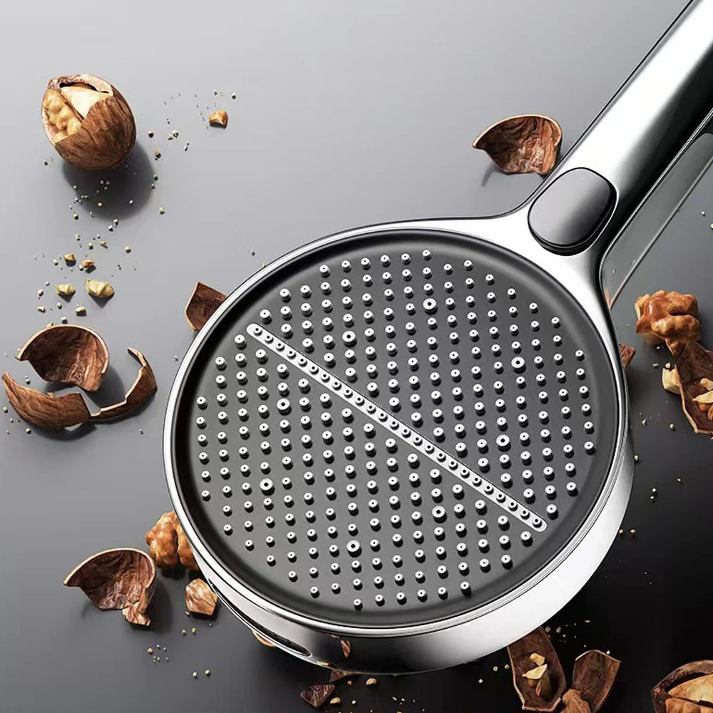 Metallic kitchen tool with textured surface on a gray background with scattered nuts.