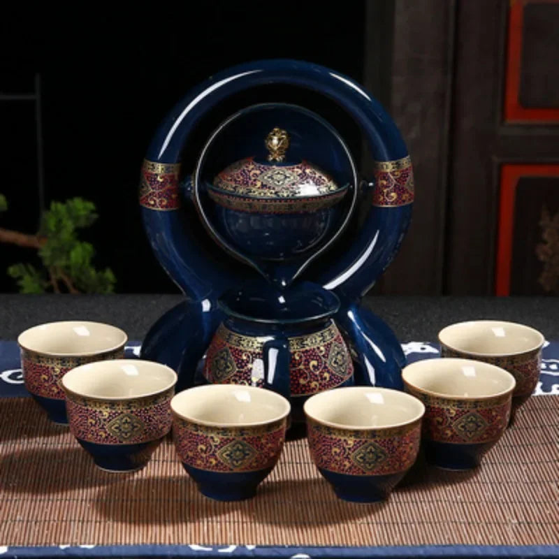 Ceramic teapot set with multiple cups on a dark surface