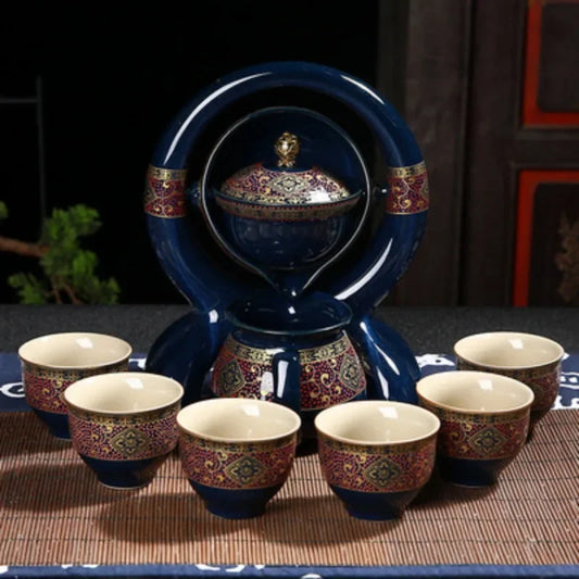 Ceramic teapot set with multiple cups on a dark surface