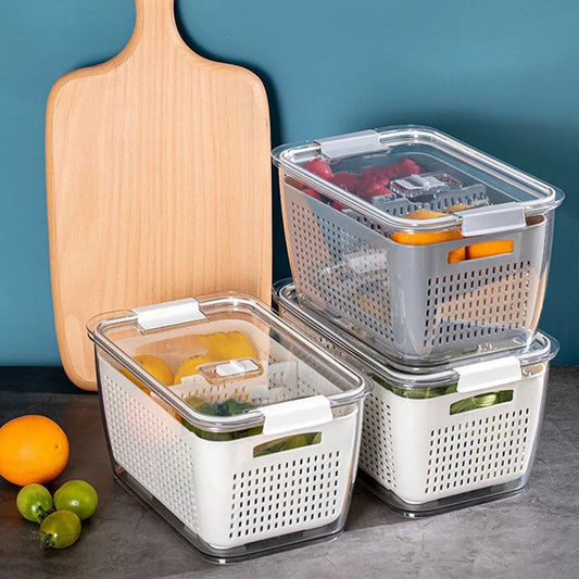 Set of three storage containers with lids on a kitchen counter with fruits and a cutting board.