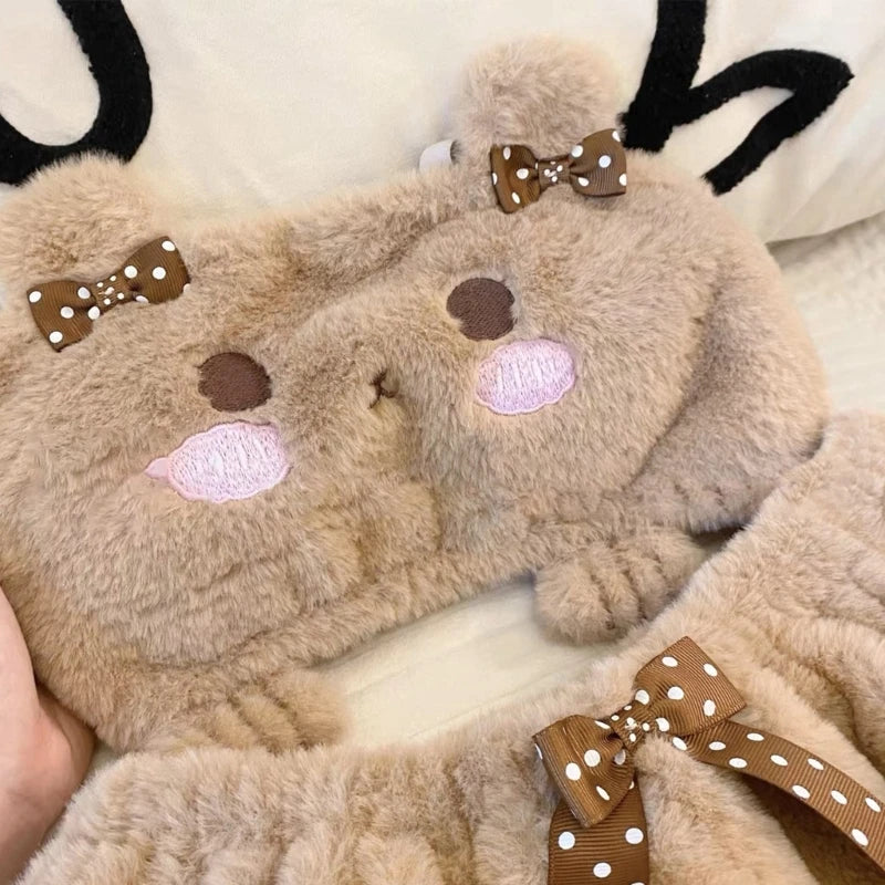 Plush reindeer toy with bow details held by a hand