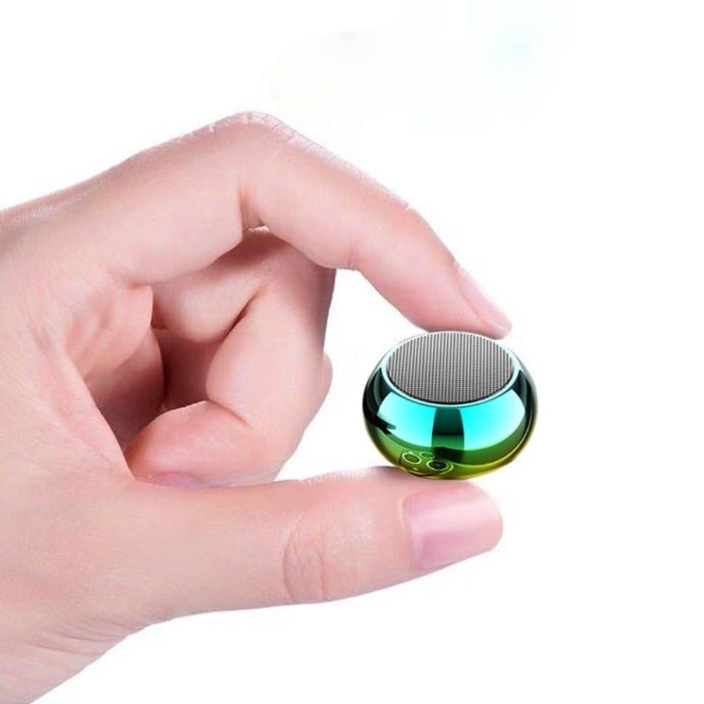 Hand holding a small, round, metallic object with a reflective surface on a white background