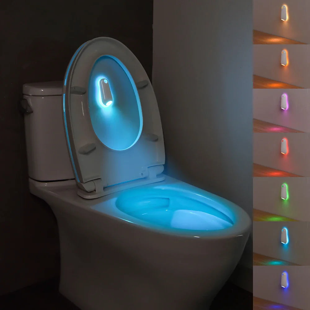Toilet with glowing seat in a dark bathroom, showing color-changing light strip on the wall.