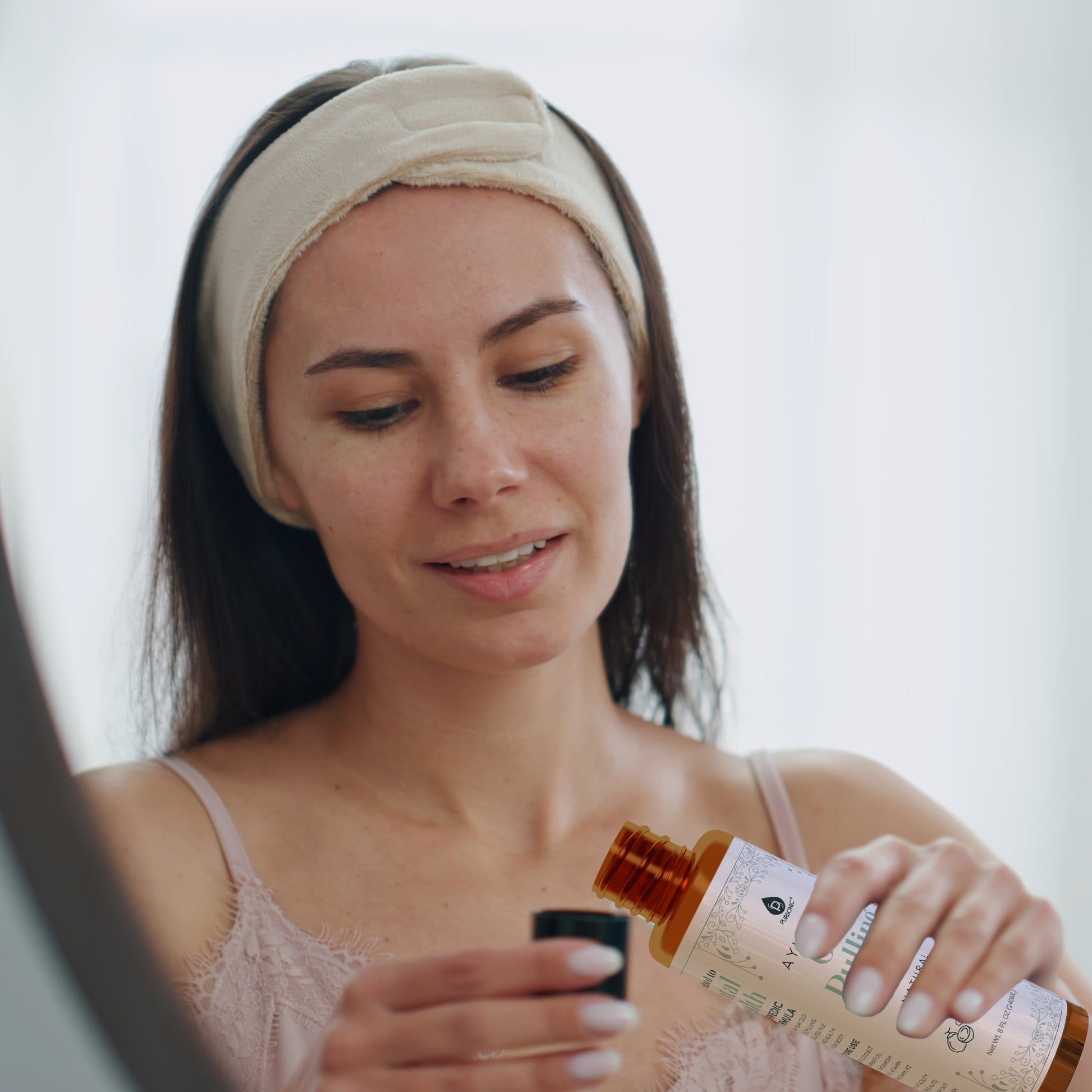 Woman applying a skincare product with a dropper bottle.