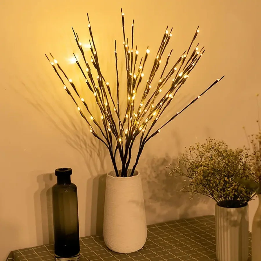 Decorative LED branch arrangement in a white vase on a tiled surface with a warm glow.
