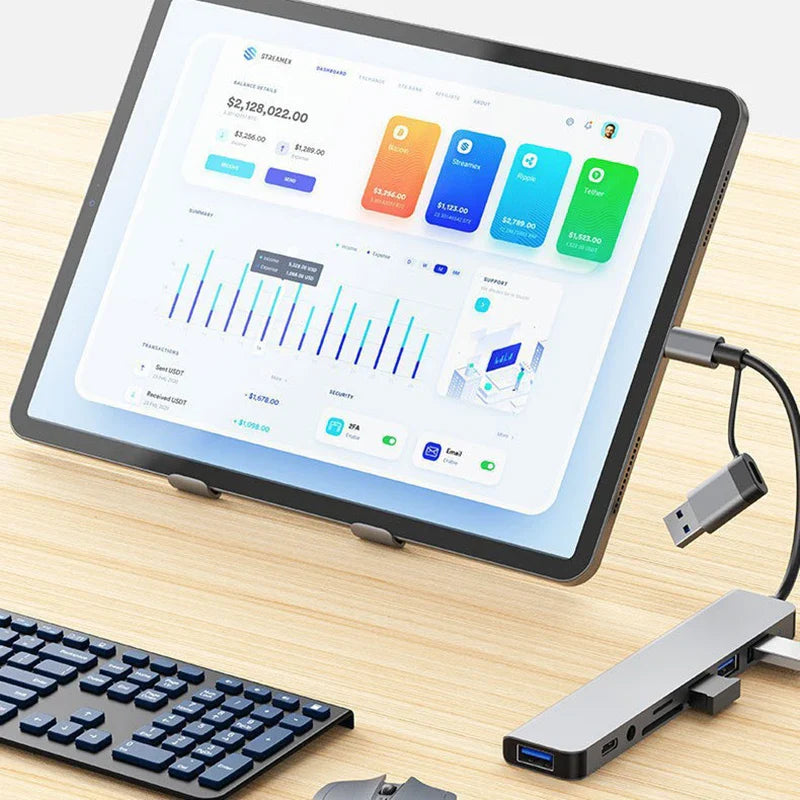 Tablet with a financial app on a desk next to a keyboard and USB hub