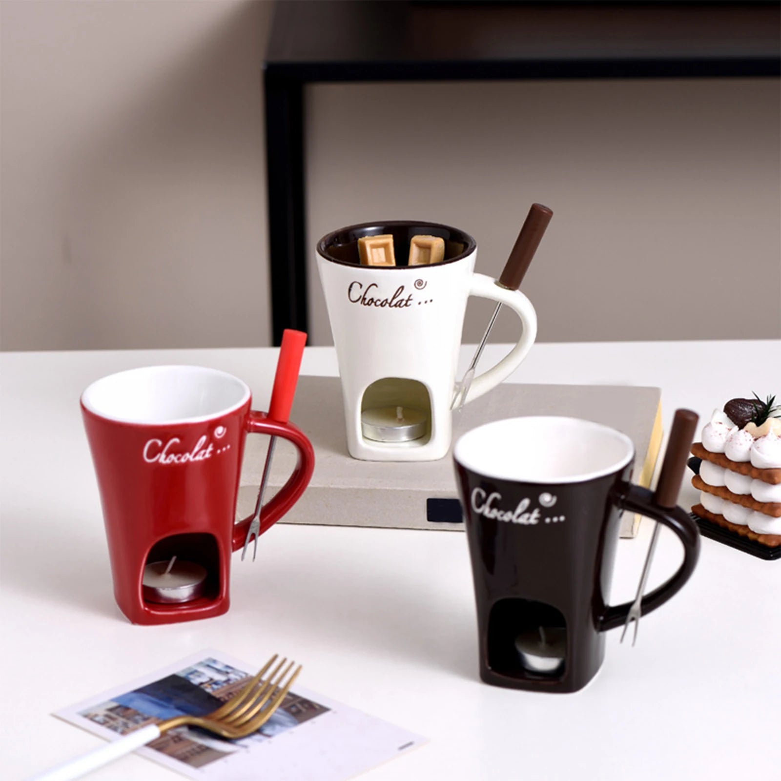 Set of three mugs with chocolate fondue pots on a table.