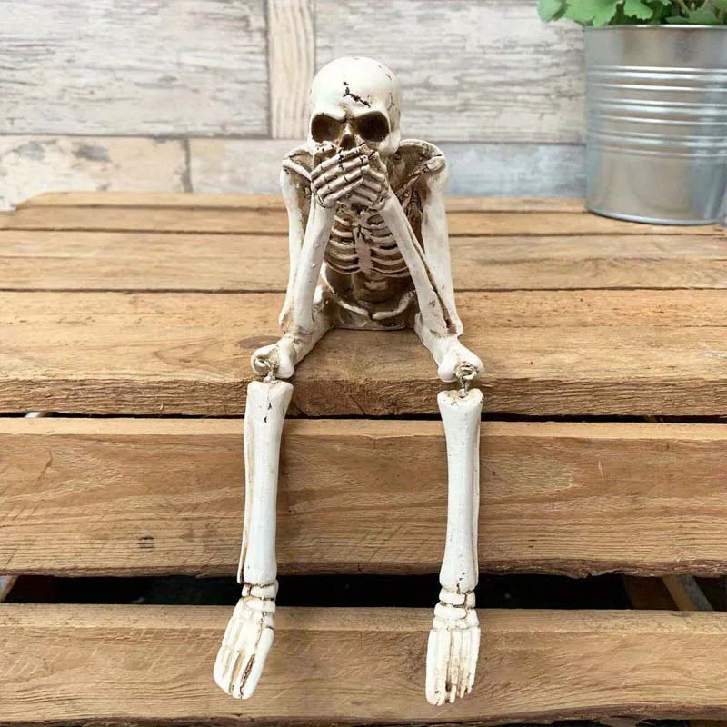Skeletal figure sitting on wooden planks with a potted plant in the background