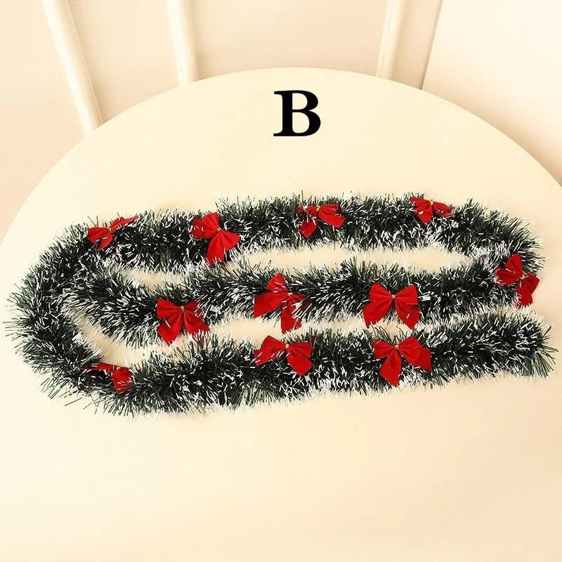 Black tinsel garland with red bows on a white chair.