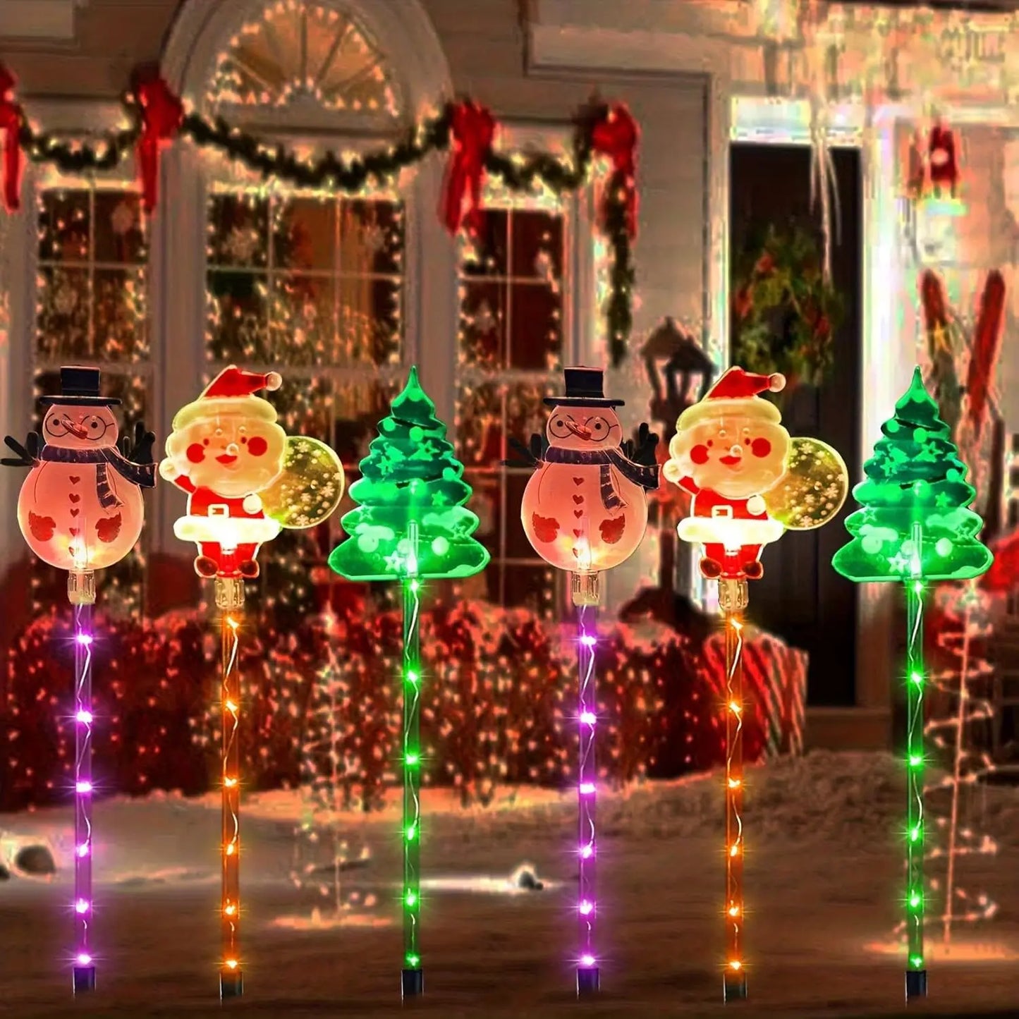 Decorative Christmas lights shaped like Santa Claus, snowmen, and trees in front of a house with holiday decorations.