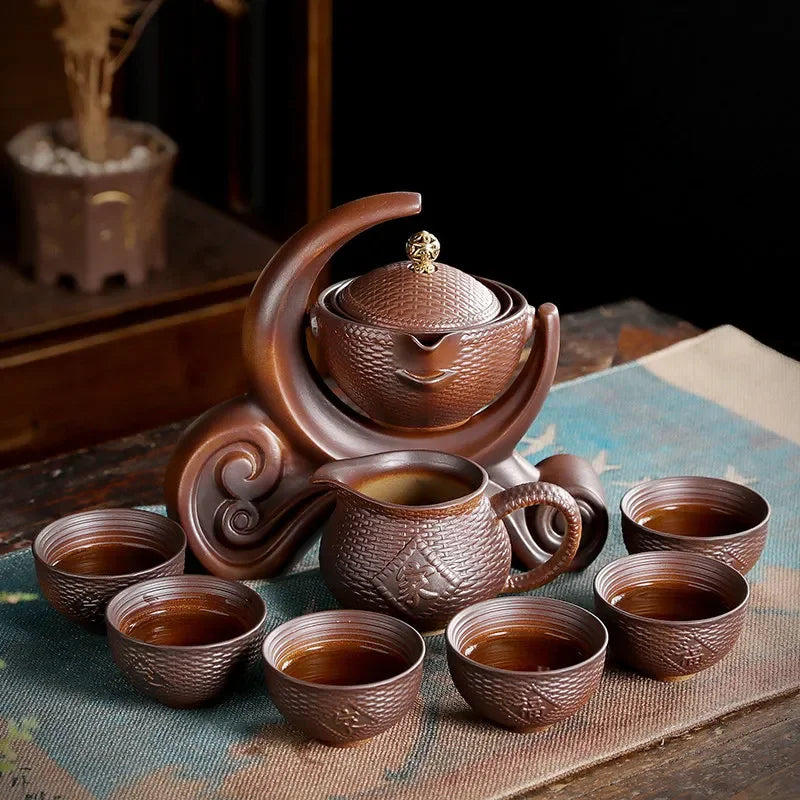 Ceramic teapot set with cups on a textured surface