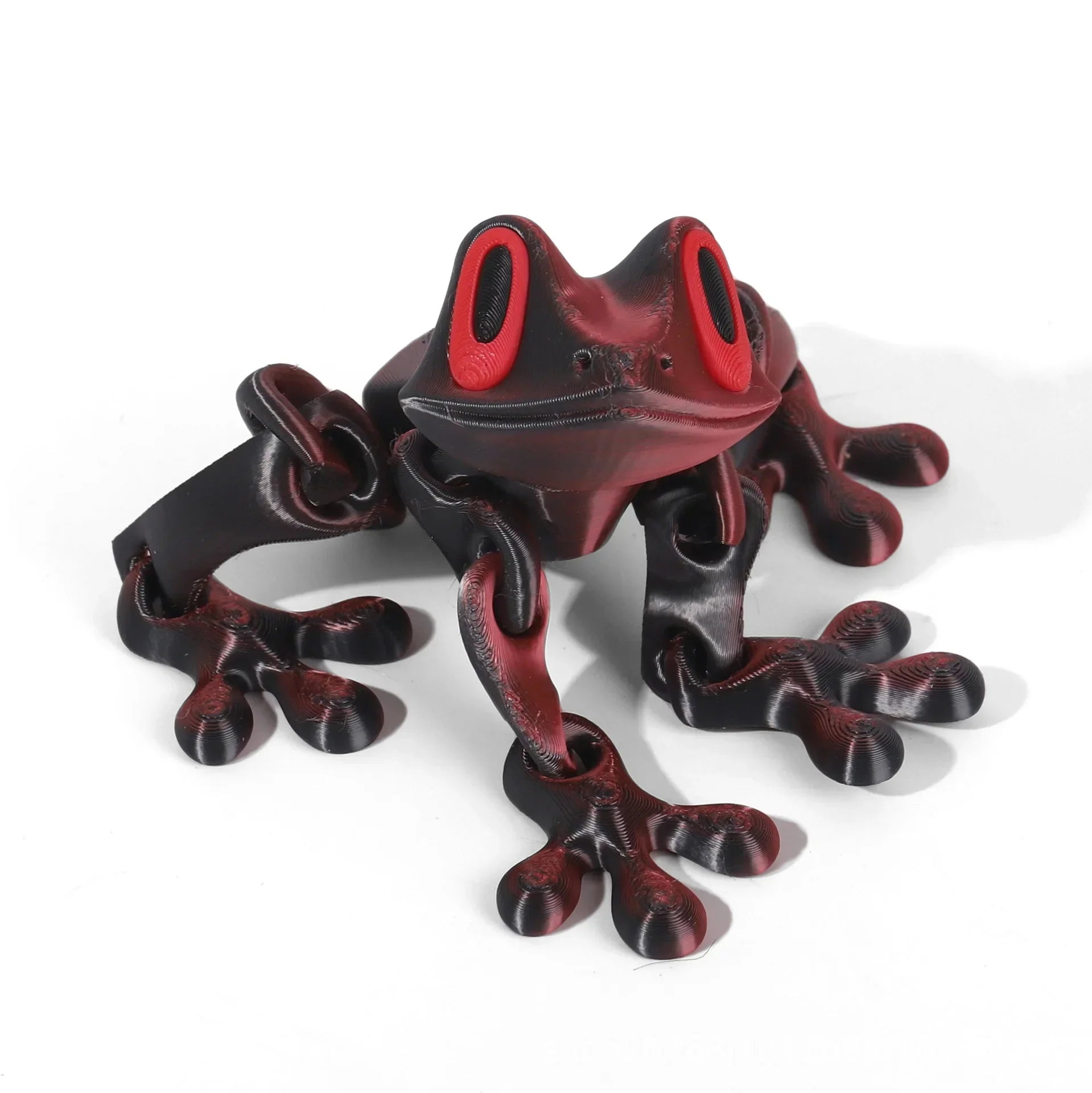 Black and red frog-shaped object on a white background