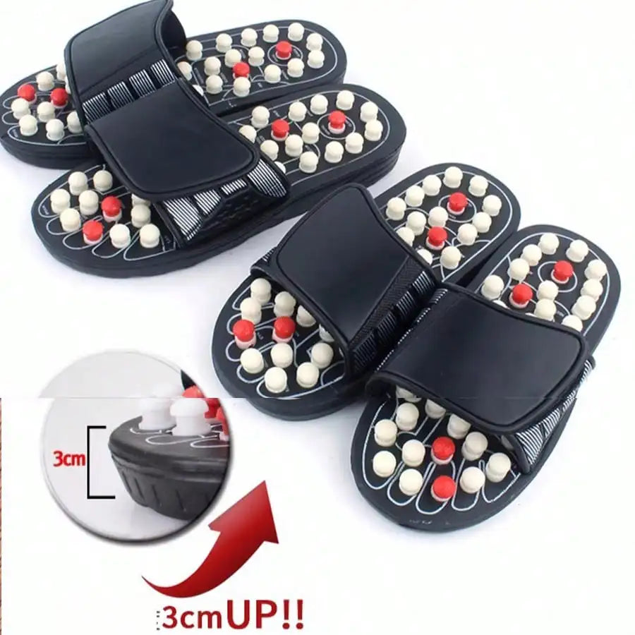 Pair of black massage sandals with acupressure nodes on a white background