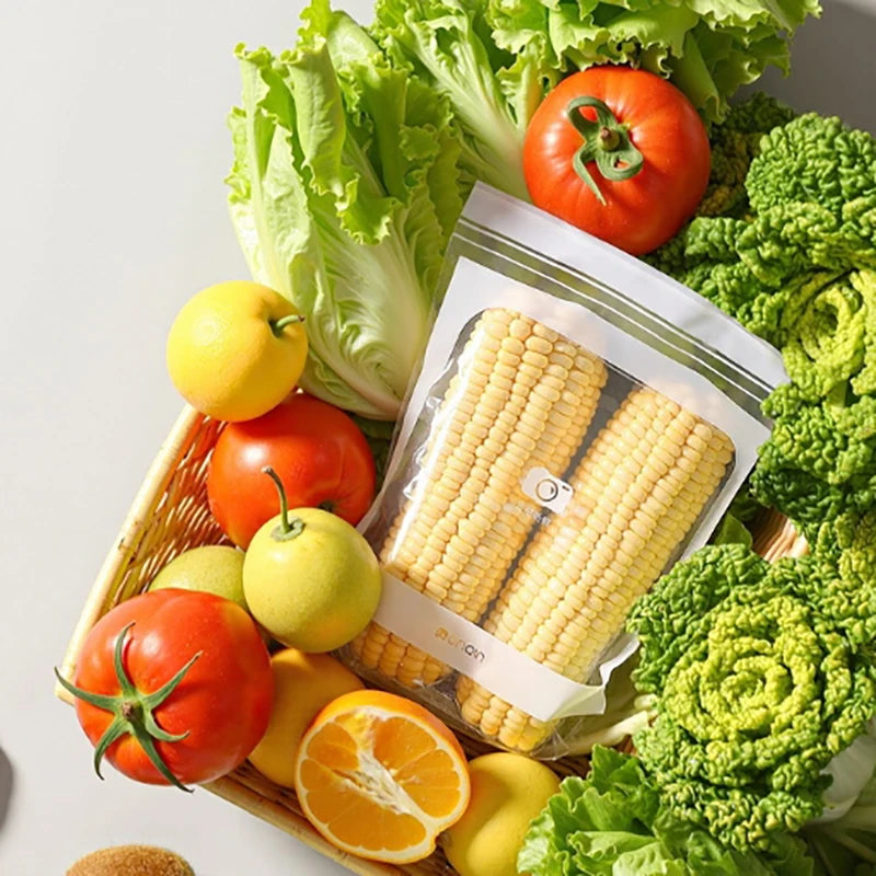 Assorted fresh fruits and vegetables including corn, tomatoes, and lettuce on a white background.