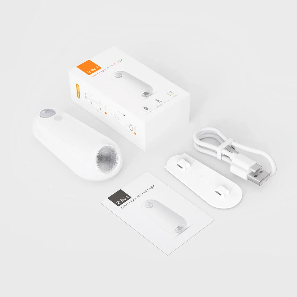 Smart home device packaging with remote control, cable, and manual on a light gray background