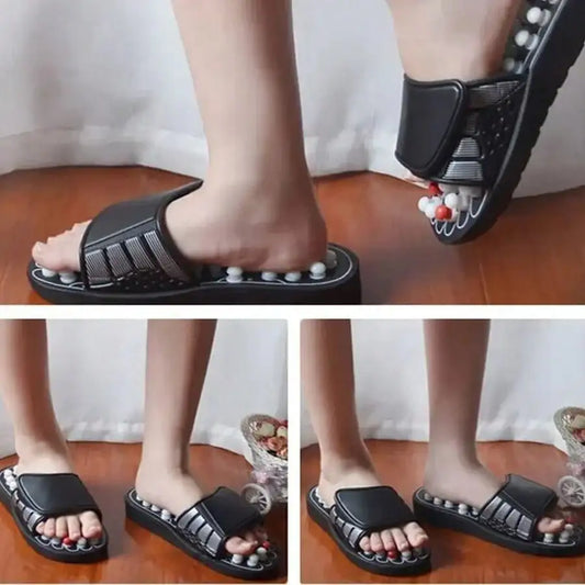 Black slippers with decorative stones worn by a person on a wooden floor.