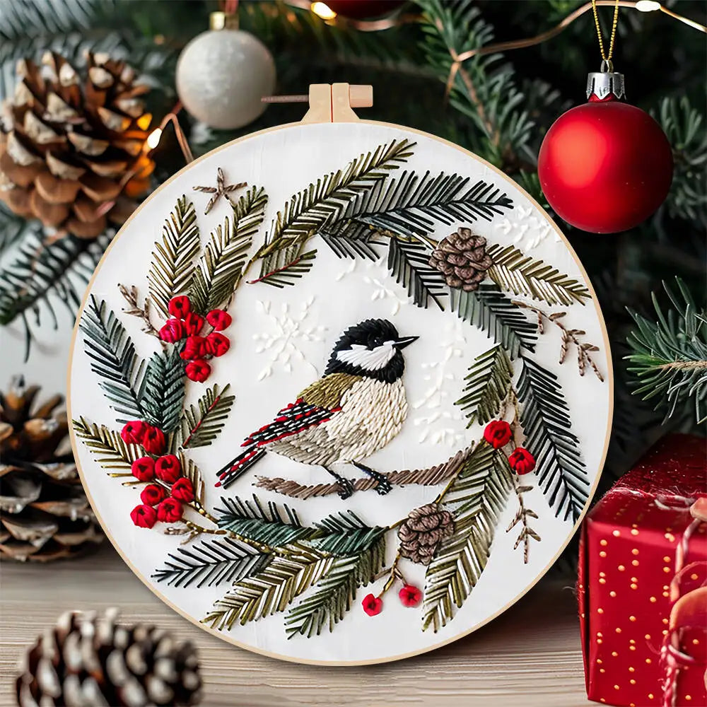 Embroidery hoop with bird design surrounded by Christmas decorations