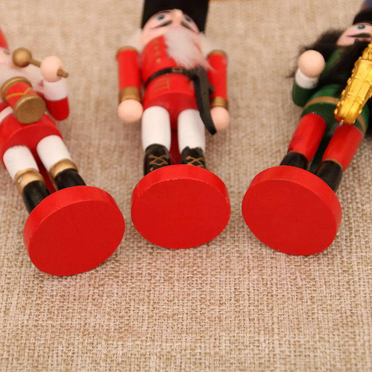 Three wooden nutcrackers with red shoes on a textured surface