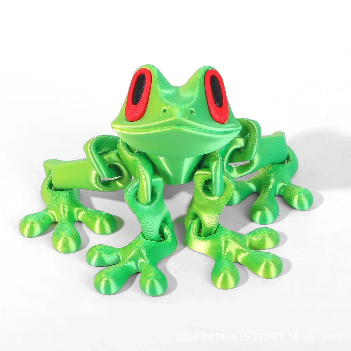 Green toy frog with red eyes on a white background