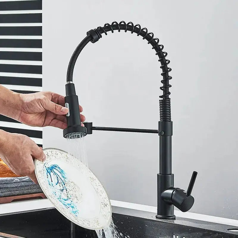 Black kitchen faucet with a person washing a plate under running water.