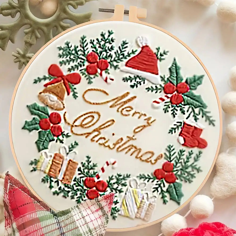 Embroidery hoop with Christmas-themed design featuring holly leaves, berries, and 'Merry Christmas' text.