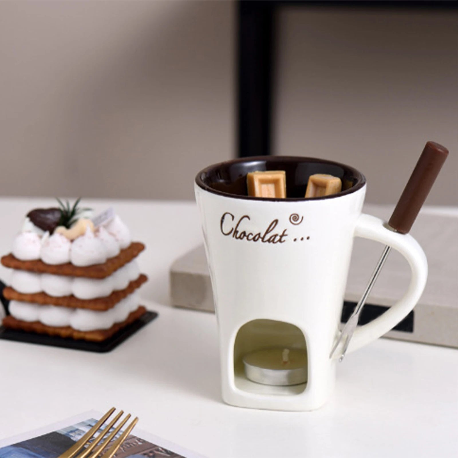 White mug with 'Chocolat' text, chocolate bar, and marshmallows on a blurred background