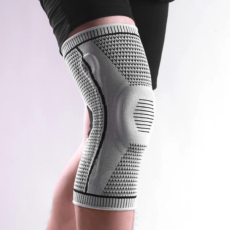 Knee brace on a person's knee with a light gray and black pattern against a white background