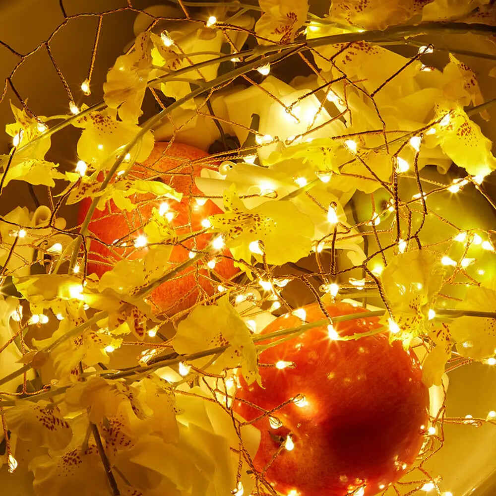 Decorative string lights on artificial flowers and pumpkins