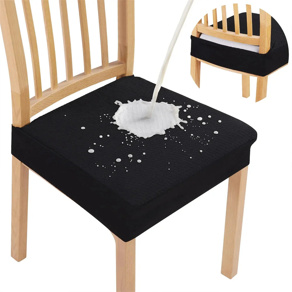 Black chair cushion with white paint splatter design on a wooden chair.