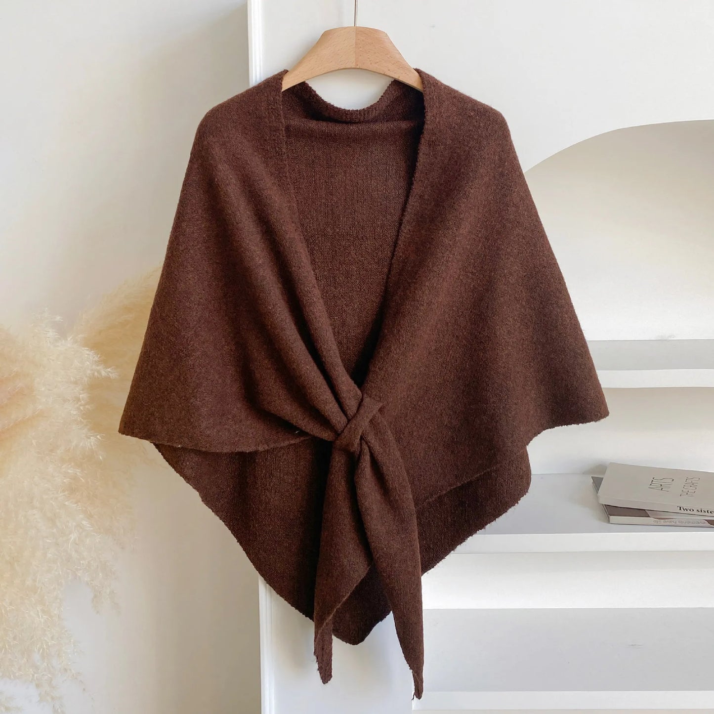 Brown poncho on a hanger against a white background