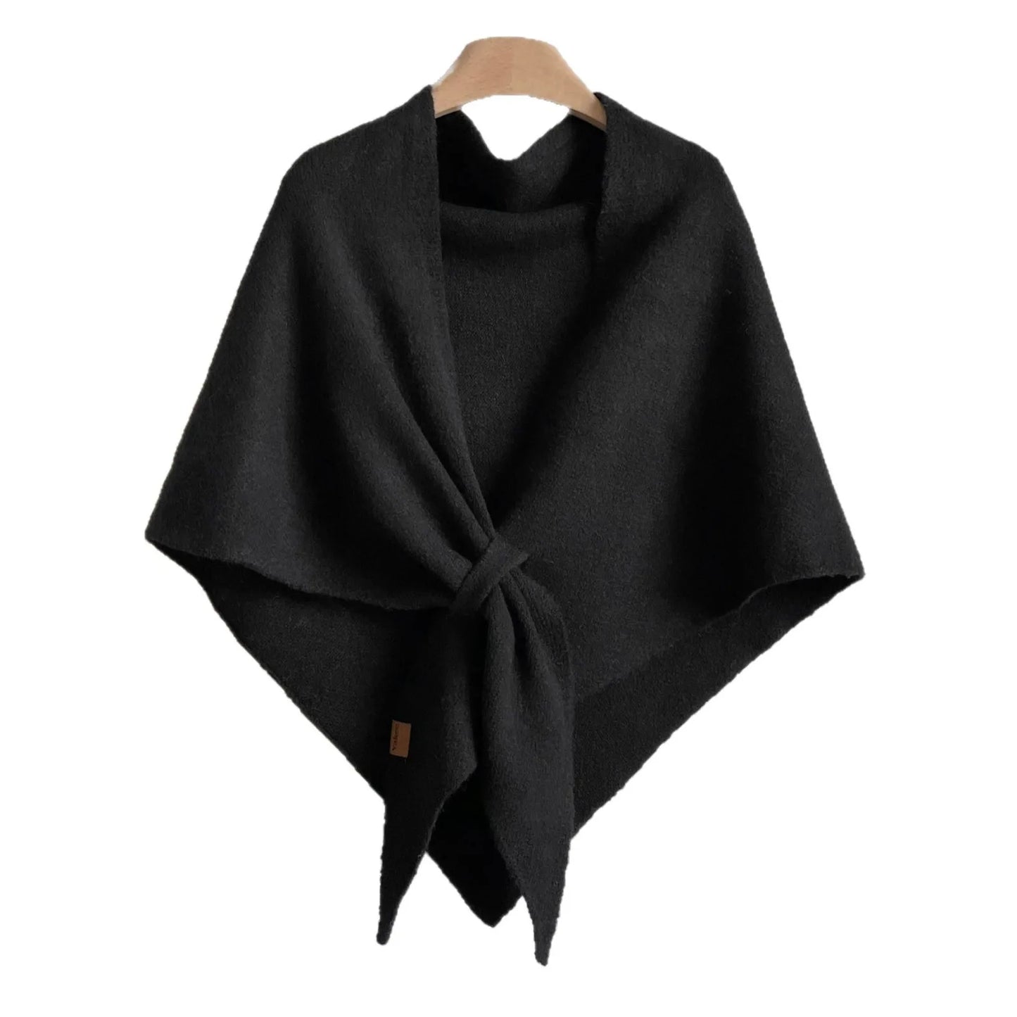 Black poncho on a wooden hanger against a white background