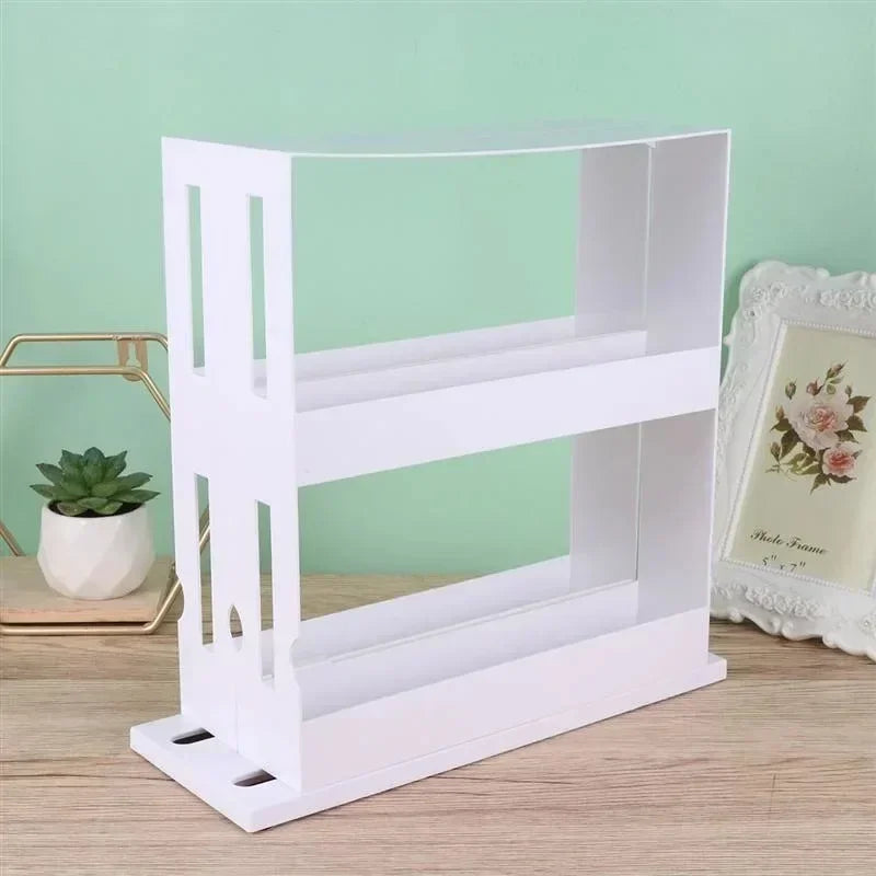 White bookshelf with a clear acrylic front on a wooden surface with a green wall background.
