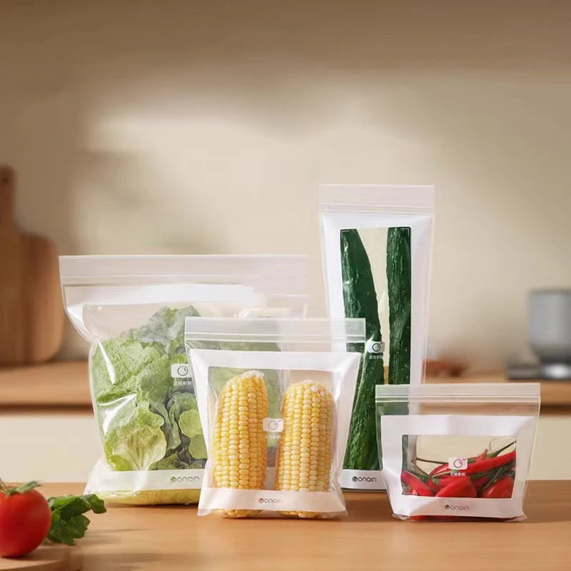 Set of vacuum-sealed bags containing vegetables on a kitchen counter.