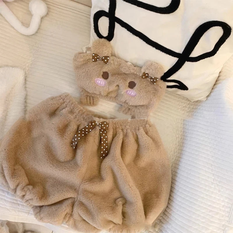 Fluffy beige baby romper with teddy bear design on a white surface