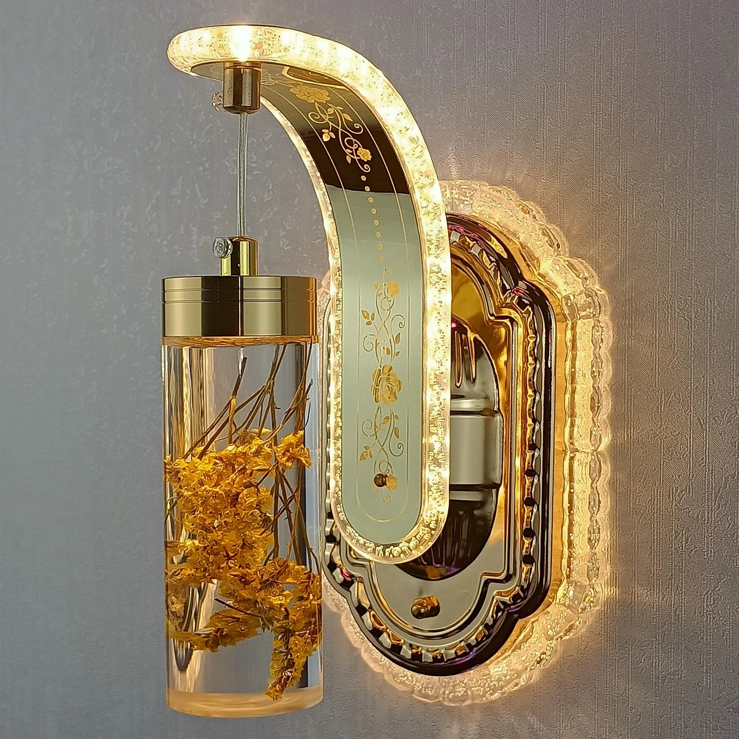 Decorative wall light fixture with gold accents and floral elements on a gray background