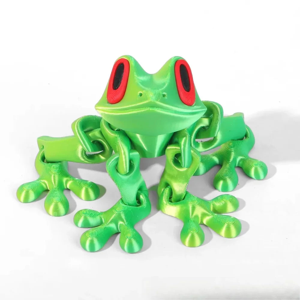 Green toy frog with red eyes on a white background