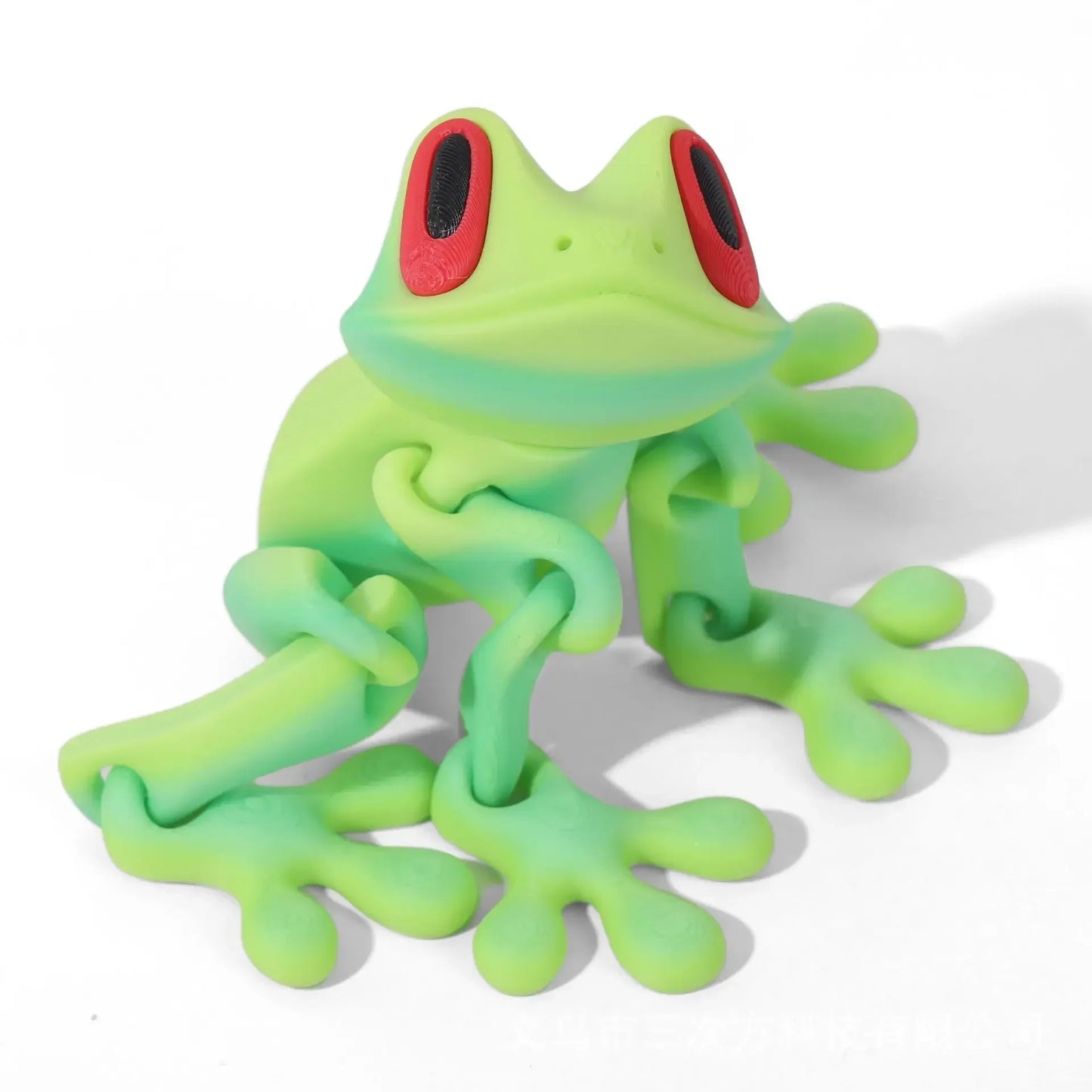Green frog figurine with red eyes on a white background